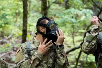 Cadet fitting a gas mask on during training