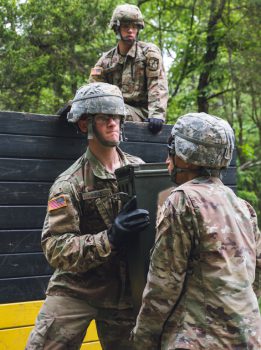 Two cadets work together to lift ammunition.
