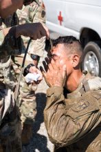 A Cadet washes the mud from his eyes and face.