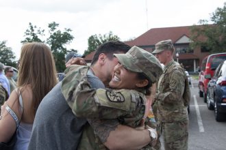 A Cadet embraces her significant other.